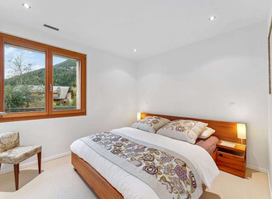 This charming bedroom features a comfortable queen-size bed with a decorative floral runner and matching pillows, creating a cozy and inviting atmosphere.
