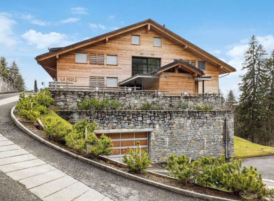 Discover this stunning wooden chalet, 'La Perle,' nestled in a picturesque mountain setting.