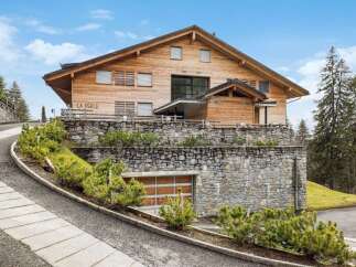 Discover this stunning wooden chalet, 'La Perle,' nestled in a picturesque mountain setting.