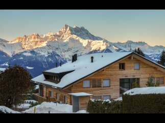 Experience the ultimate alpine retreat in this stunning wooden chalet, perfectly situated against a backdrop of majestic snow-capped mountains.