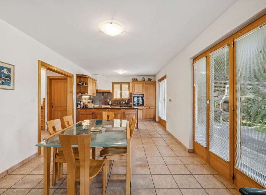 This charming kitchen and dining area features warm wooden cabinetry and a spacious dining table perfect for family meals.