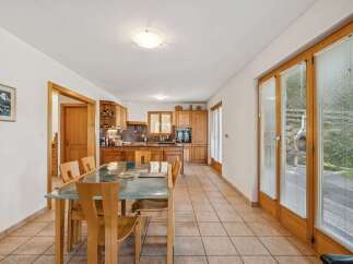 This charming kitchen and dining area features warm wooden cabinetry and a spacious dining table perfect for family meals.