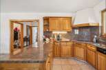 Discover this charming kitchen featuring warm wooden cabinetry and a stunning granite countertop that extends into a breakfast bar.