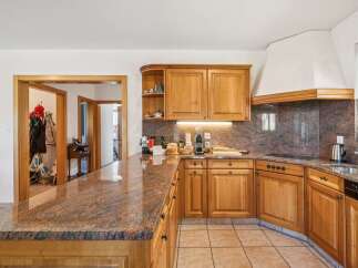 Discover this charming kitchen featuring warm wooden cabinetry and a stunning granite countertop that extends into a breakfast bar.