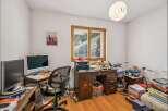 This home office features a spacious wooden desk equipped with a printer and multiple monitors, perfect for productivity.