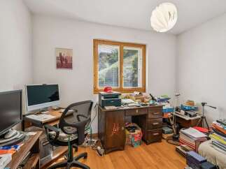 This home office features a spacious wooden desk equipped with a printer and multiple monitors, perfect for productivity.