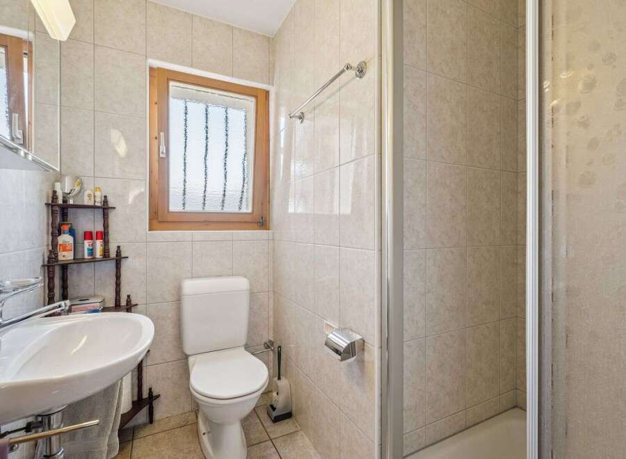 This charming bathroom features a clean white toilet and a spacious sink with a chrome faucet, perfect for daily routines.