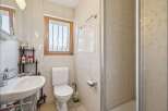 This charming bathroom features a clean white toilet and a spacious sink with a chrome faucet, perfect for daily routines.