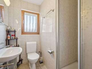 This charming bathroom features a clean white toilet and a spacious sink with a chrome faucet, perfect for daily routines.