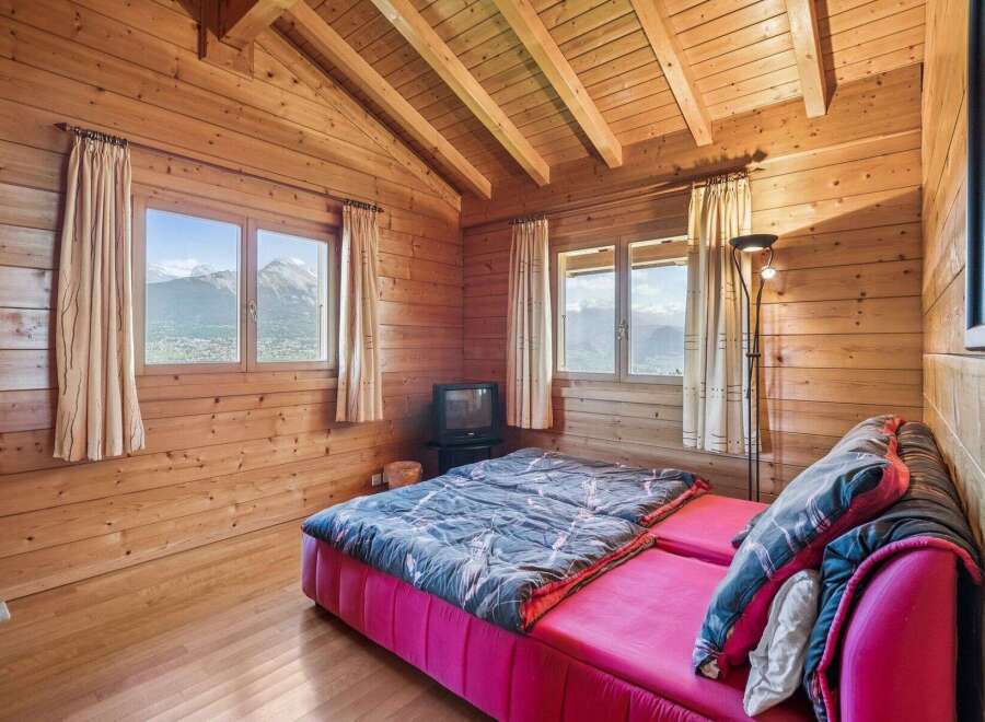 Experience cozy mountain living in this charming wooden cabin bedroom.