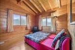 Experience cozy mountain living in this charming wooden cabin bedroom.