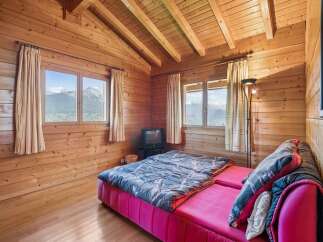 Experience cozy mountain living in this charming wooden cabin bedroom.