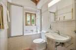 This charming bathroom features a bathtub with a sliding glass door, perfect for a relaxing soak.