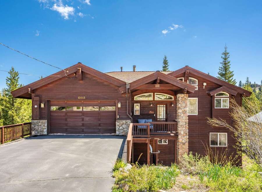 Nestled amidst lush greenery and tall pine trees, this stunning wooden home offers a serene mountain retreat.