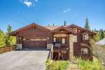 Nestled amidst lush greenery and tall pine trees, this stunning wooden home offers a serene mountain retreat.