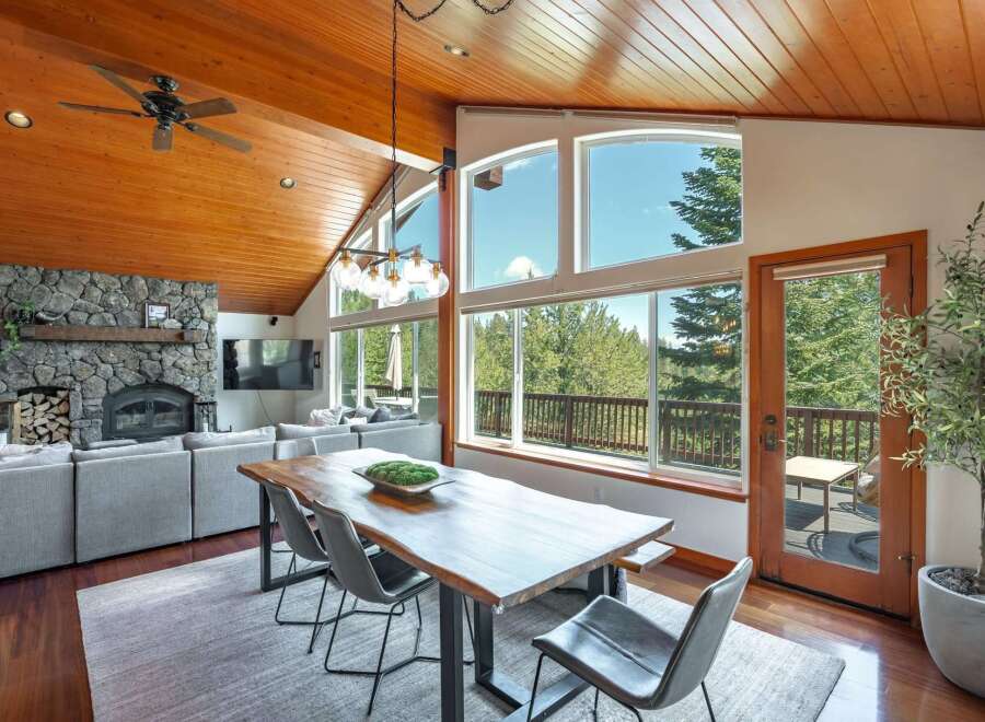 Experience breathtaking mountain views from this stunning dining area, featuring a live-edge wood table and comfortable seating.