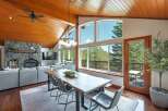 Experience breathtaking mountain views from this stunning dining area, featuring a live-edge wood table and comfortable seating.