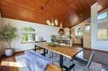 Experience rustic charm and modern comfort in this open-concept dining and kitchen area, featuring a stunning live-edge dining table and a spacious island perfect for entertaining.