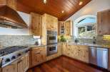 Experience rustic charm in this beautifully appointed kitchen, featuring warm knotty pine cabinetry and a stunning granite countertop.