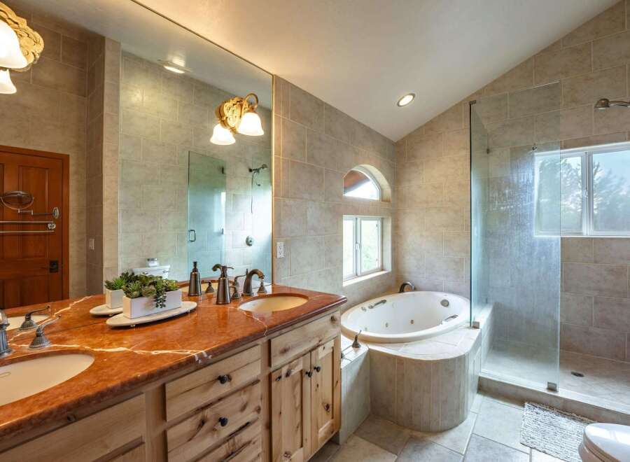 Indulge in luxury in this stunning master bathroom, featuring a spacious dual vanity with a beautiful marble countertop and elegant fixtures.