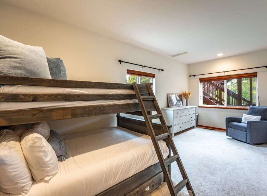 This charming bedroom features a rustic wooden bunk bed, perfect for accommodating guests or family.