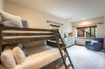 This charming bedroom features a rustic wooden bunk bed, perfect for accommodating guests or family.