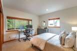 This inviting bedroom features a dedicated workspace with dual monitors, perfect for remote work or study.