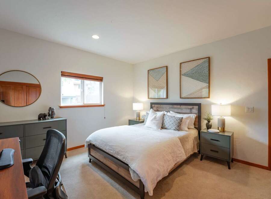 Discover comfort and style in this inviting bedroom, featuring a cozy bed with crisp white linens and decorative pillows.