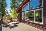 Enjoy the serene mountain views from this charming cabin's spacious deck, complete with comfortable hanging chairs and a coffee table.