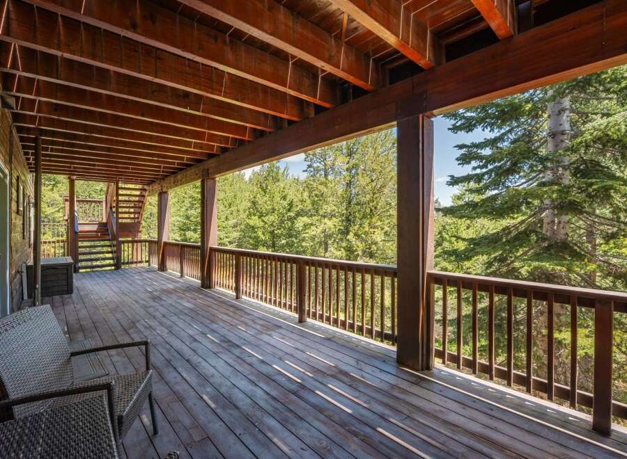 Enjoy the serene mountain views from this expansive wooden deck, perfect for outdoor living and entertaining.