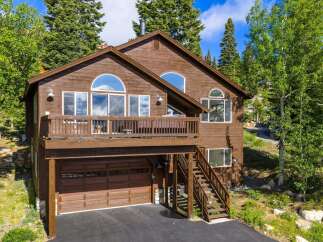 Nestled amidst lush greenery, this charming wooden home offers a serene mountain retreat.