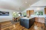 Experience modern living in this stunning kitchen and dining area, featuring a sleek dark island with ample storage and a bright, airy dining space.