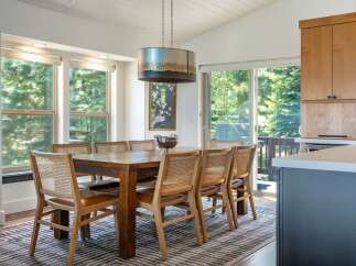 This dining area features a large wooden table with cane-backed chairs, perfect for family gatherings.