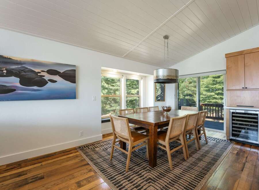 This dining room boasts a large wooden table with six chairs, perfect for family gatherings.