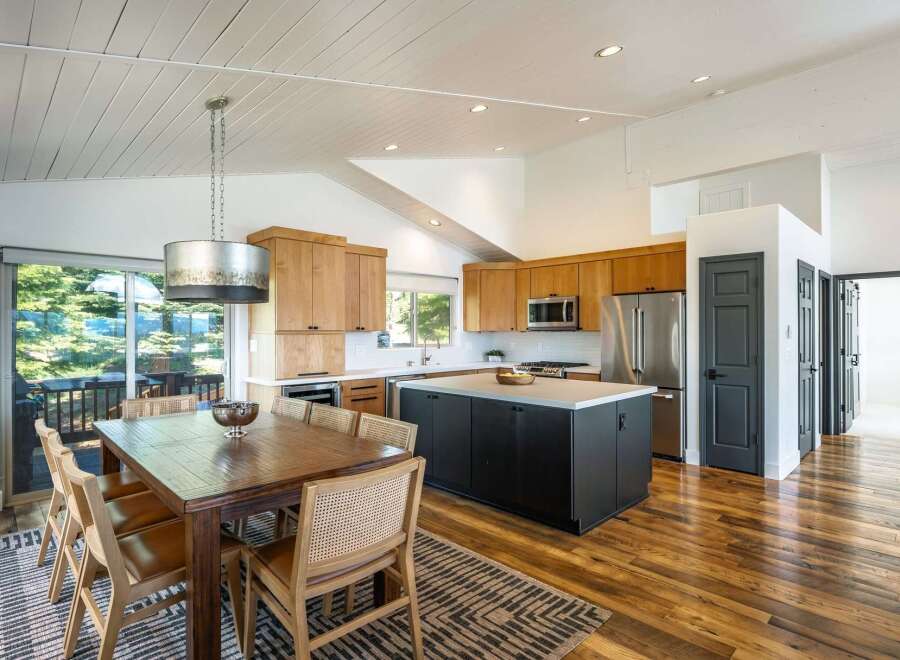 Experience modern living in this stunning kitchen and dining area, featuring sleek wood cabinetry and a spacious island perfect for entertaining.