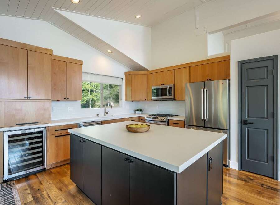 Experience modern living in this stunning kitchen featuring sleek, light wood cabinetry and a spacious white island perfect for meal prep and entertaining.