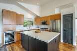 Experience modern living in this stunning kitchen featuring sleek, light wood cabinetry and a spacious white island perfect for meal prep and entertaining.