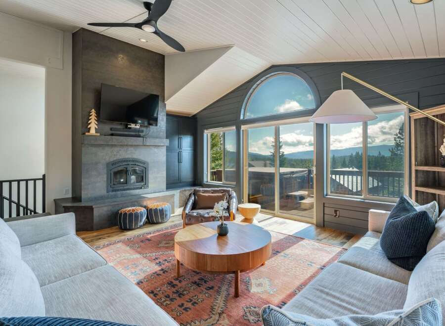 Experience breathtaking mountain views from this stunning living room, featuring a modern fireplace and expansive windows that flood the space with natural light.
