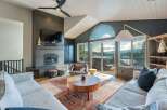 Experience breathtaking mountain views from this stunning living room, featuring a modern fireplace and expansive windows that flood the space with natural light.