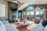 Experience breathtaking mountain views from this stunning living room, featuring a modern fireplace and expansive windows that flood the space with natural light.