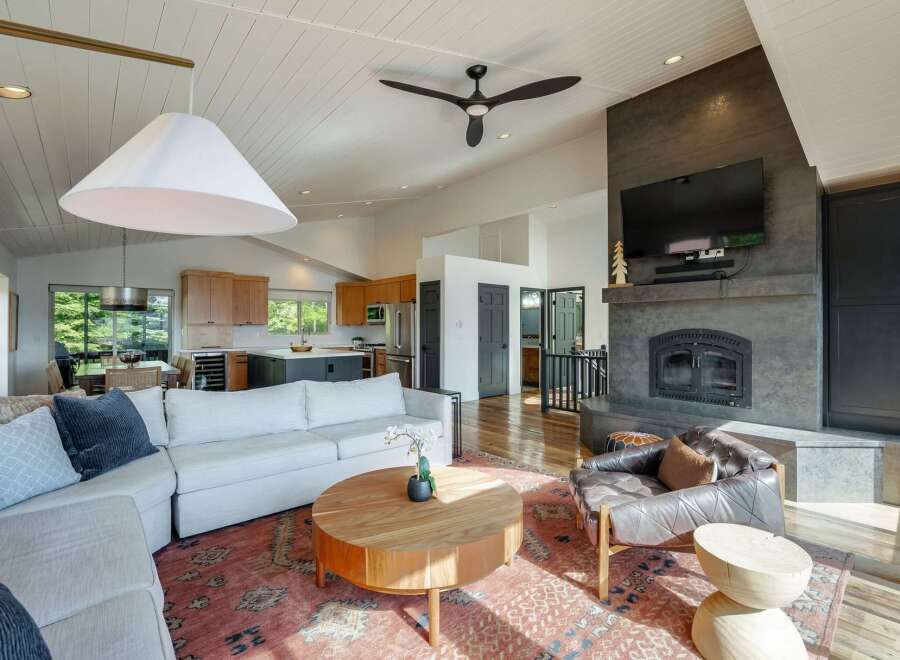 Experience modern living in this spacious open-concept home, featuring a stunning vaulted ceiling with a contemporary fan and a large pendant light.