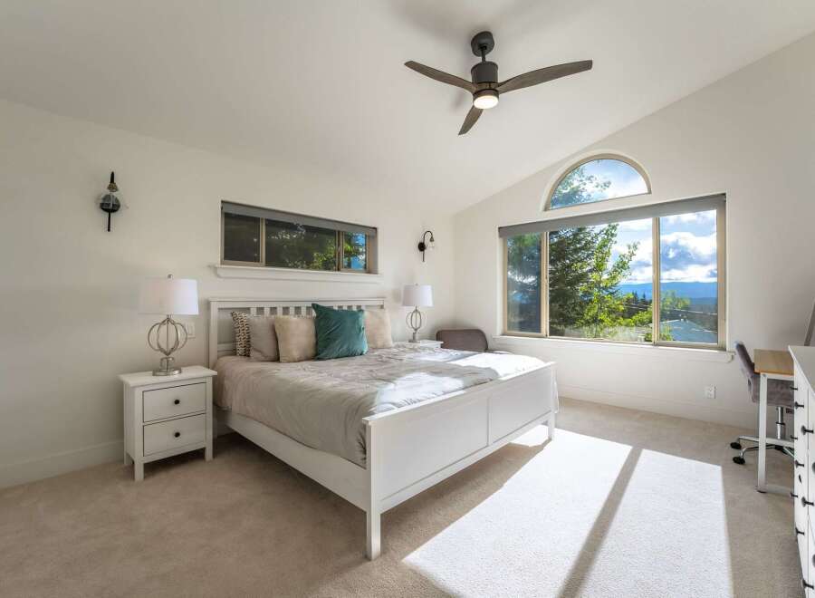 Experience breathtaking mountain views from this serene bedroom, featuring a comfortable king-size bed and ample natural light.