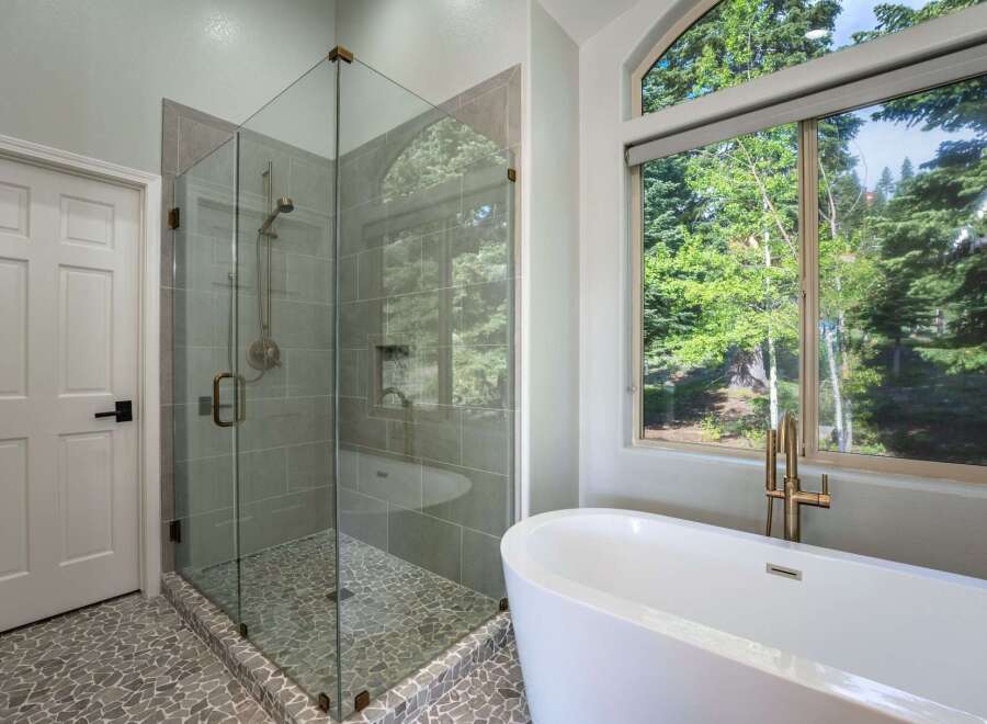 Experience luxury in this stunning bathroom featuring a spacious glass-enclosed shower with elegant tile work and a sleek rainfall showerhead.