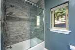 Experience modern comfort in this bathroom featuring a sleek glass shower enclosure over a pristine white bathtub.