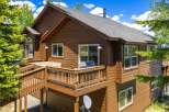 Experience mountain living in this charming wooden home, featuring a spacious wrap-around deck perfect for outdoor entertaining and enjoying the scenic views.