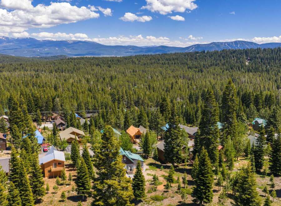 Nestled amidst a dense forest of evergreen trees, this charming mountain community offers a serene escape.