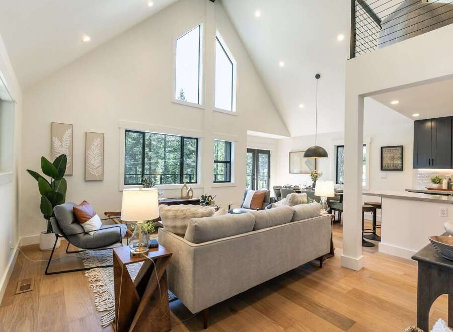 Experience modern living in this stunning open-concept home, featuring soaring vaulted ceilings and expansive windows that flood the space with natural light.