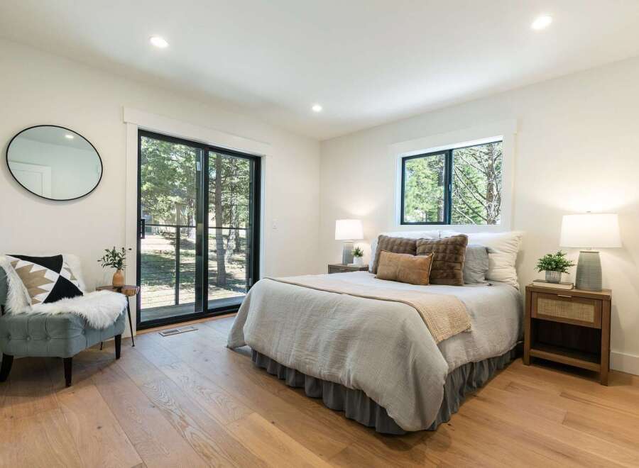 Experience serene living in this beautifully appointed bedroom, featuring a comfortable bed dressed in soft, neutral linens and accented with plush throw pillows.