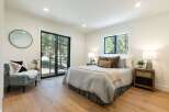Experience serene living in this beautifully appointed bedroom, featuring a comfortable bed dressed in soft, neutral linens and accented with plush throw pillows.