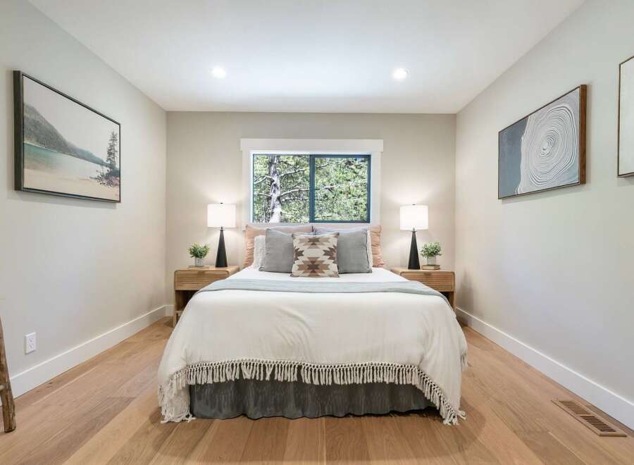This serene bedroom offers a tranquil retreat with its neutral color palette and natural wood accents.
